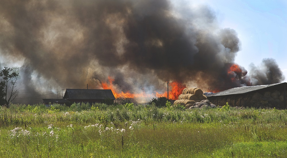 Een vreselijke brand van een hooi pakhuis in het dorp, DDekk via iStock