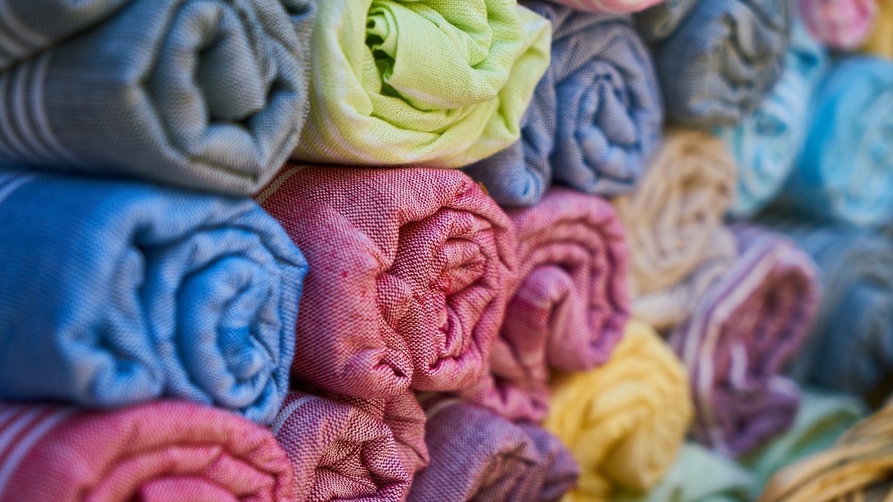 Stapel opgerolde textiele handdoeken in verschillende kleuren - Engin Akyurt via Pixabay